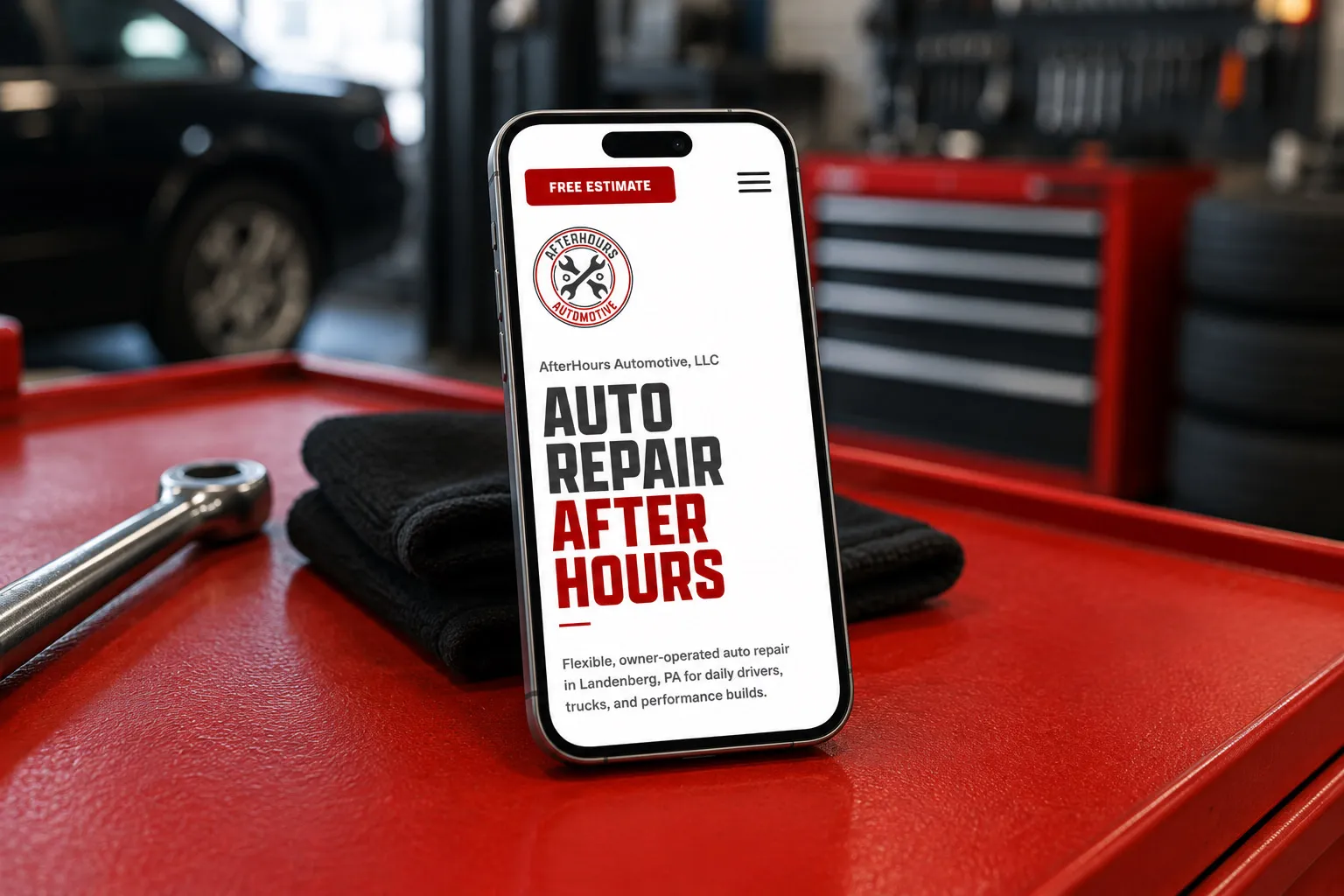 AfterHours Automotive mobile website shown on a phone in an auto repair shop