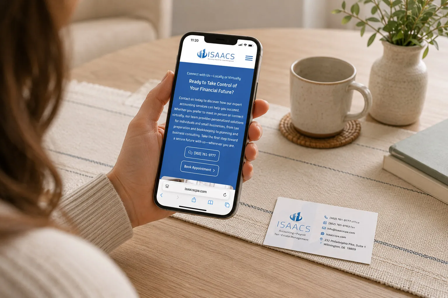 Isaacs & Associates mobile website shown on a phone beside a printed business card